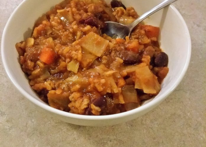 Cabbage roll soup in a white bowl.