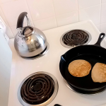 Easy Homemade Old-Fashioned Pancakes frying in a cast iron pan