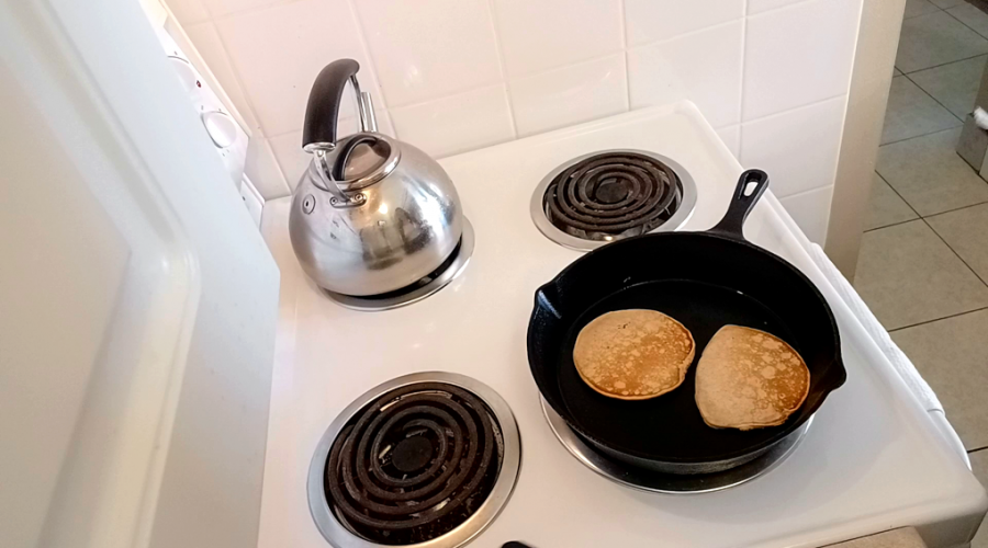 Easy Homemade Old-Fashioned Pancakes frying in a cast iron pan